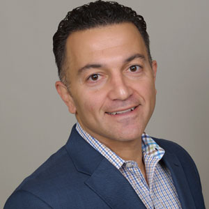 A man in a suit and tie smiling for the camera.