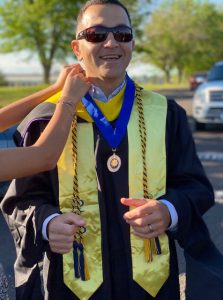 A person putting medals on their graduation robe